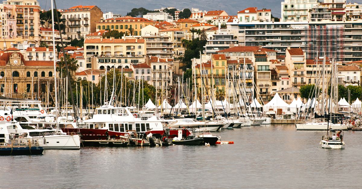 Beautiful view of Cannes harbor with moored yachts and historic buildings, capturing the essence of French Riviera charm.